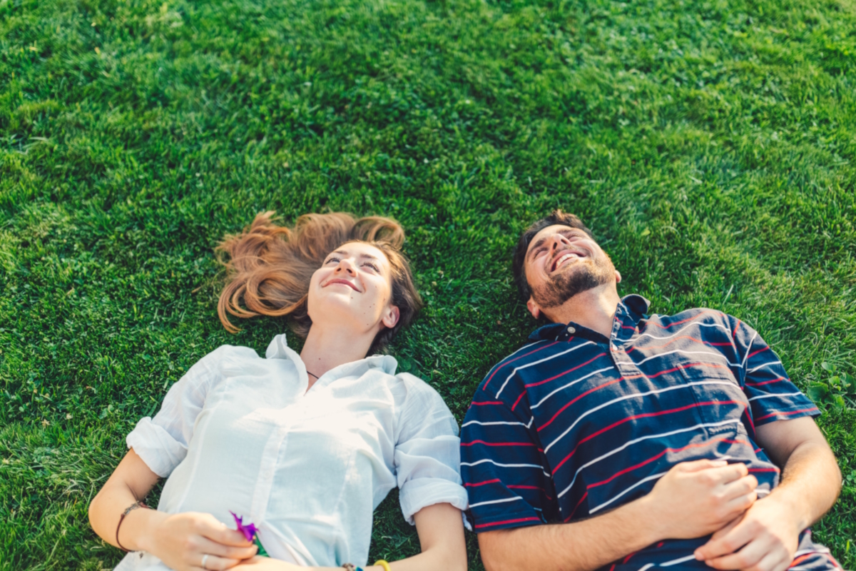 Happy couple in the grass dreaming